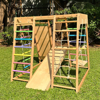 Casa Bambini Wooden Jungle Gym 7-in-1 full setup in living room: climbing wall, slide and swing for ages 1-6