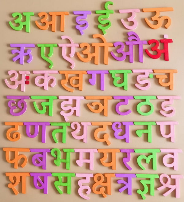 Wooden Hindi Varnamala learning board with all colorful alphabet pieces displayed.