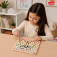 Child creating a colourful pattern on a wooden threading board with a needle and thread