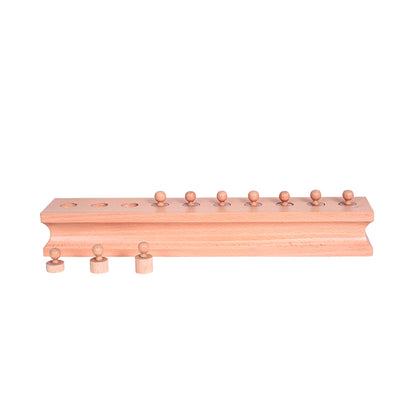 Child refitting cylinders in Casa Bambini Knobbed Cylinder Block: self-correcting Montessori size discrimination
